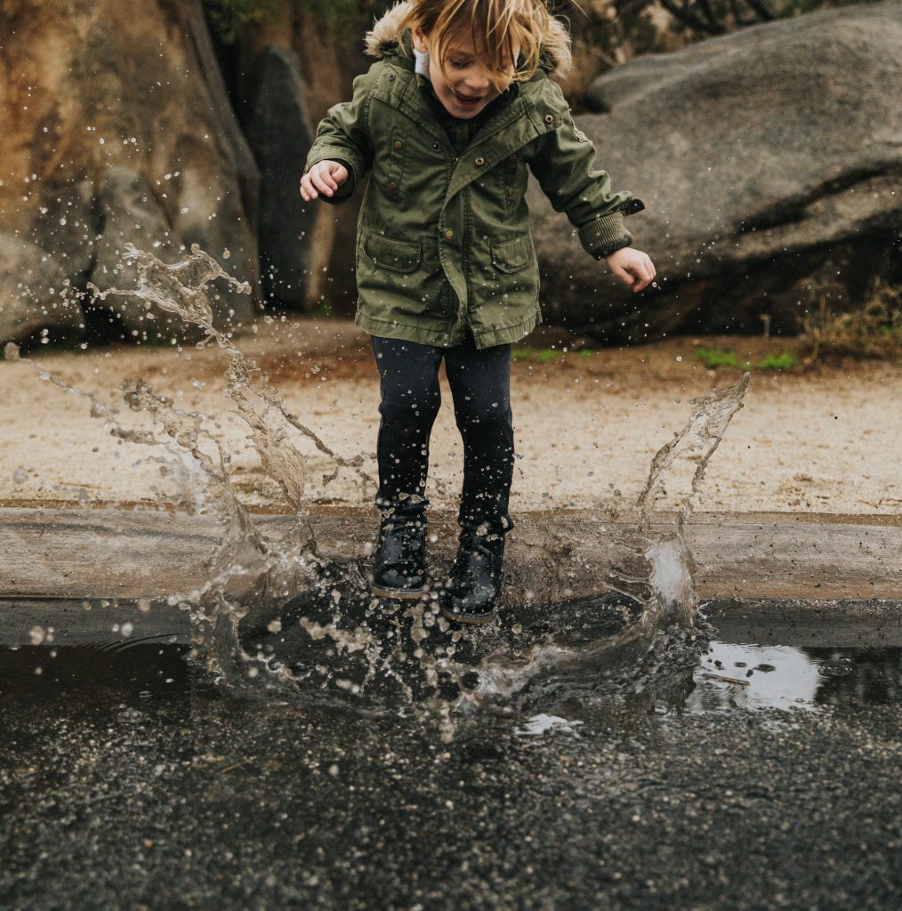 Girl jumping in puddle